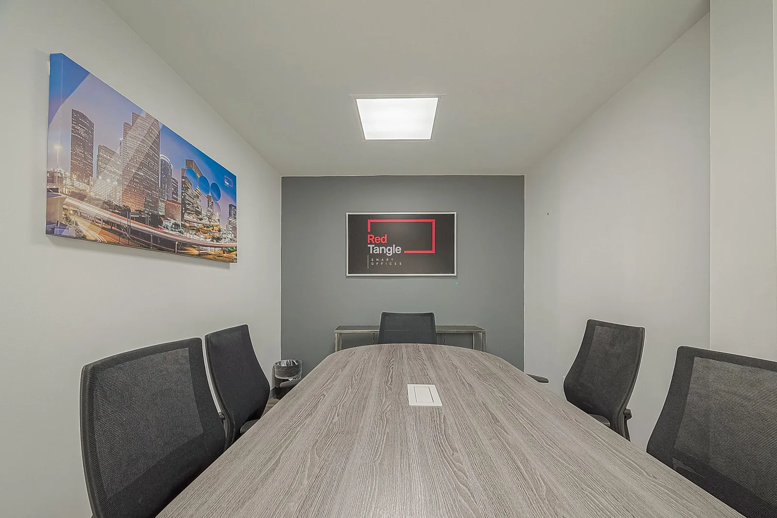 Private meeting room with conference table and presentation screen at Red Tangle Smart Offices, Magnolia, Texas